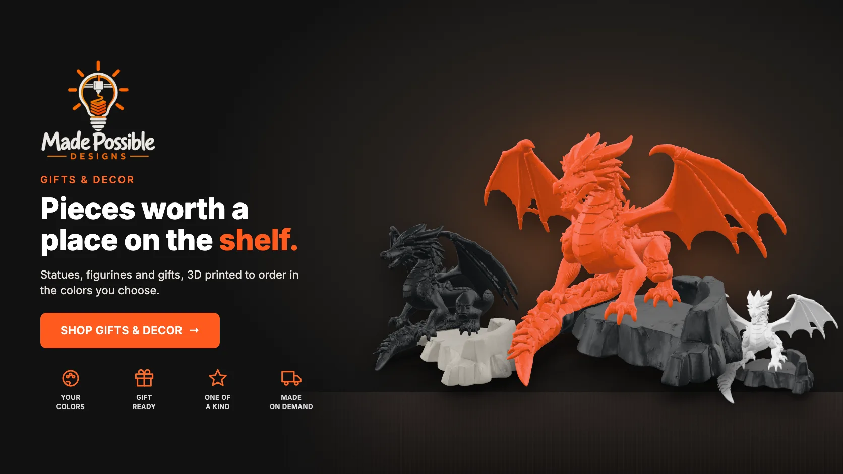 Three 3D-printed dragon statues on a dark shelf: a Signal Orange dragon on a graphite rock, a graphite dragon on a stone rock and a white dragon on a graphite rock.